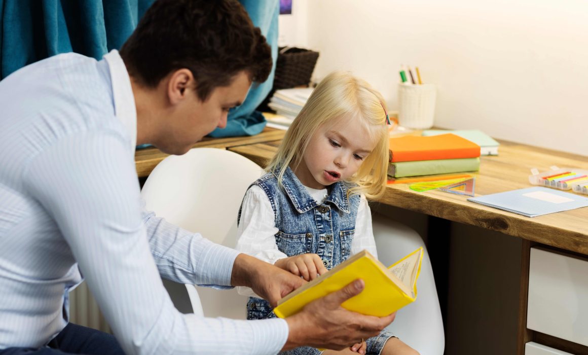 side view father helping girl read.jpg